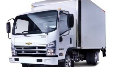 Caminhão urbano branco com emblema Chevrolet e carroceria tipo baú.