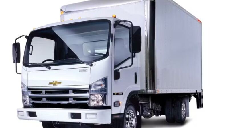 Caminhão urbano branco com emblema Chevrolet e carroceria tipo baú.