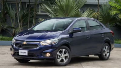 Chevrolet Prisma azul estacionado, visto de frente e de lado.