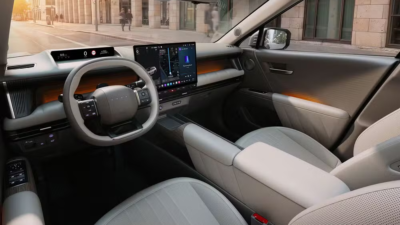 Cabine de SUV com volante e telas digitais no painel.