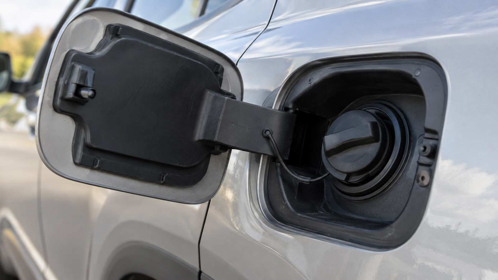 Portinhola e tampa do tanque de combustível de um automóvel
