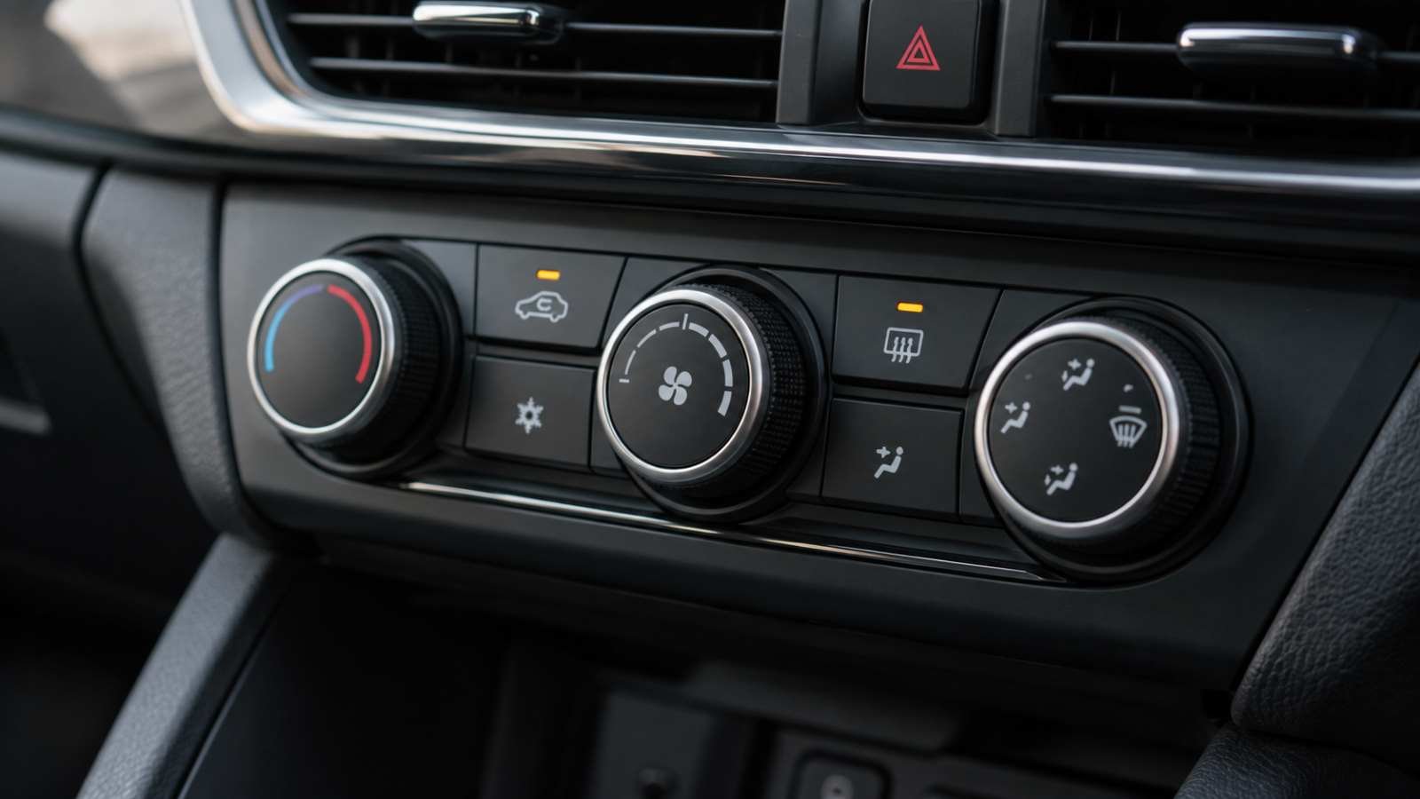 Comandos de ventilação e desembaçamento no painel de um carro